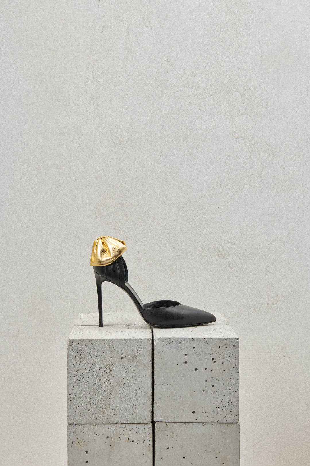 PUMPS IN BLACK LEATHER WITH POINT AND GOLD BOW ON THE HEEL